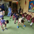 Montessori children stretch together during a morning exercise session