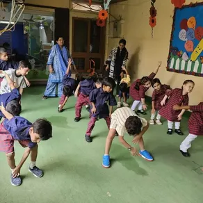 Montessori children stretch together during a morning exercise session
