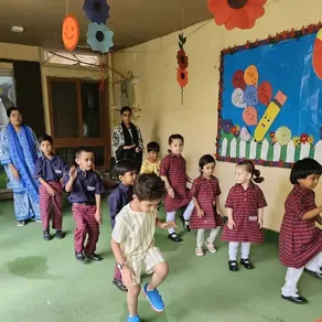 Montessori children take part in a morning movement activity in the Spring Buds play area