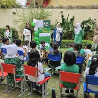 Student presenters read aloud at the Independence Day assembly while classmates listen