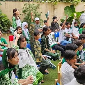 Spring Buds students seated in the garden for the Independence Day assembly