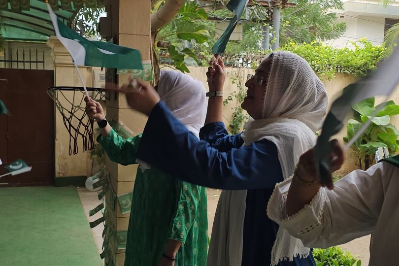 Spring Buds teachers raise Pakistan flags on the school porch on Independence Day
